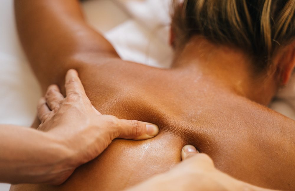 Therapist applying firm pressure during a deep tissue massage at Stillwater Wellness