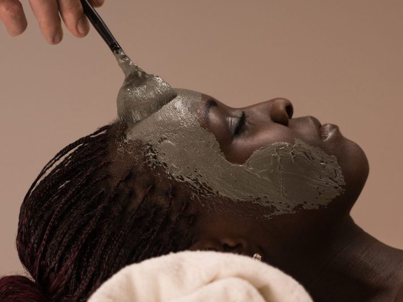 Client enjoying a clay mask facial treatment at Stillwater Wellness