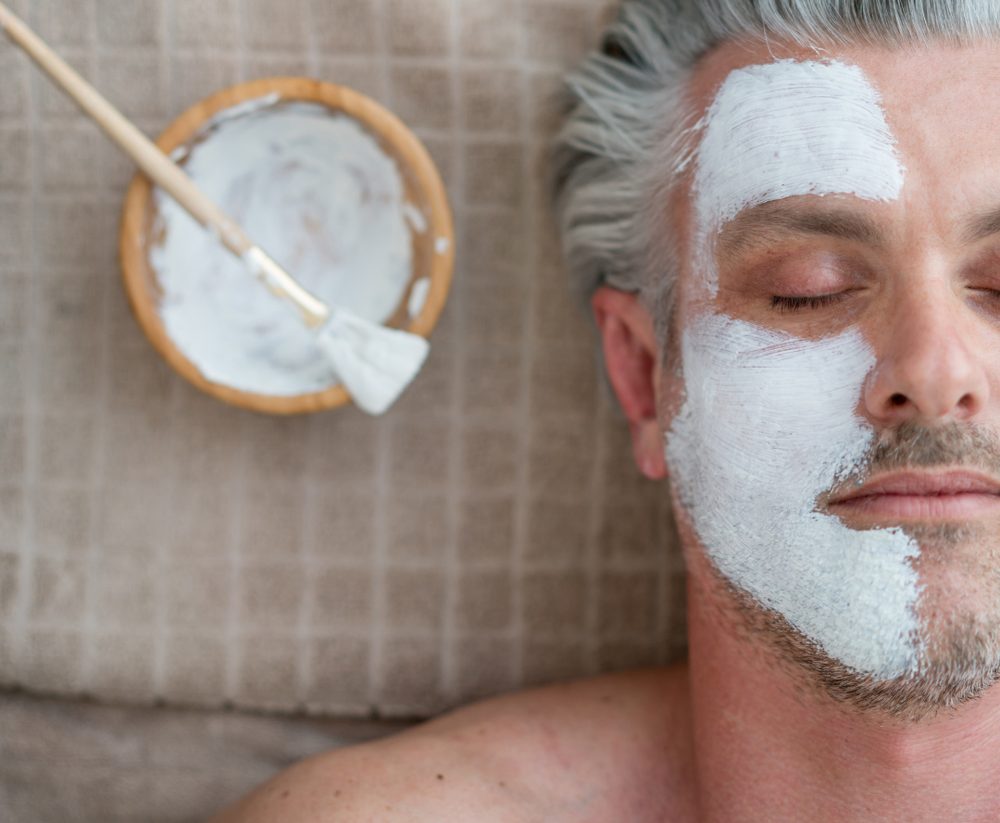 Client relaxing during a clay mask facial treatment