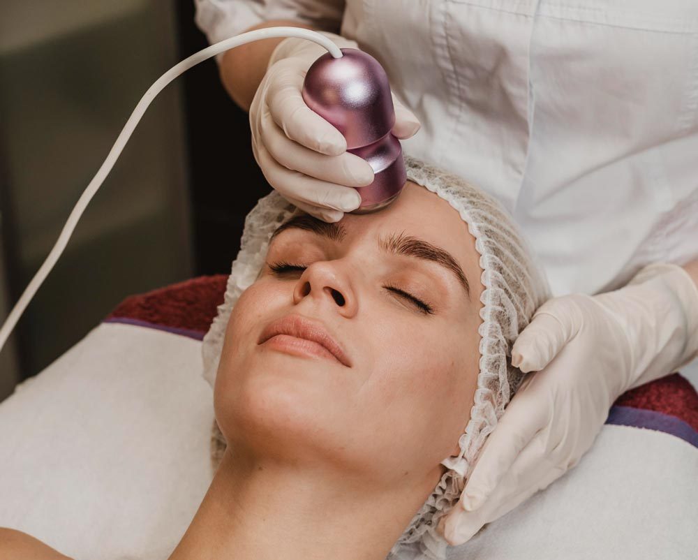Microchanneling device being glided across a client’s cheek during a skincare treatment