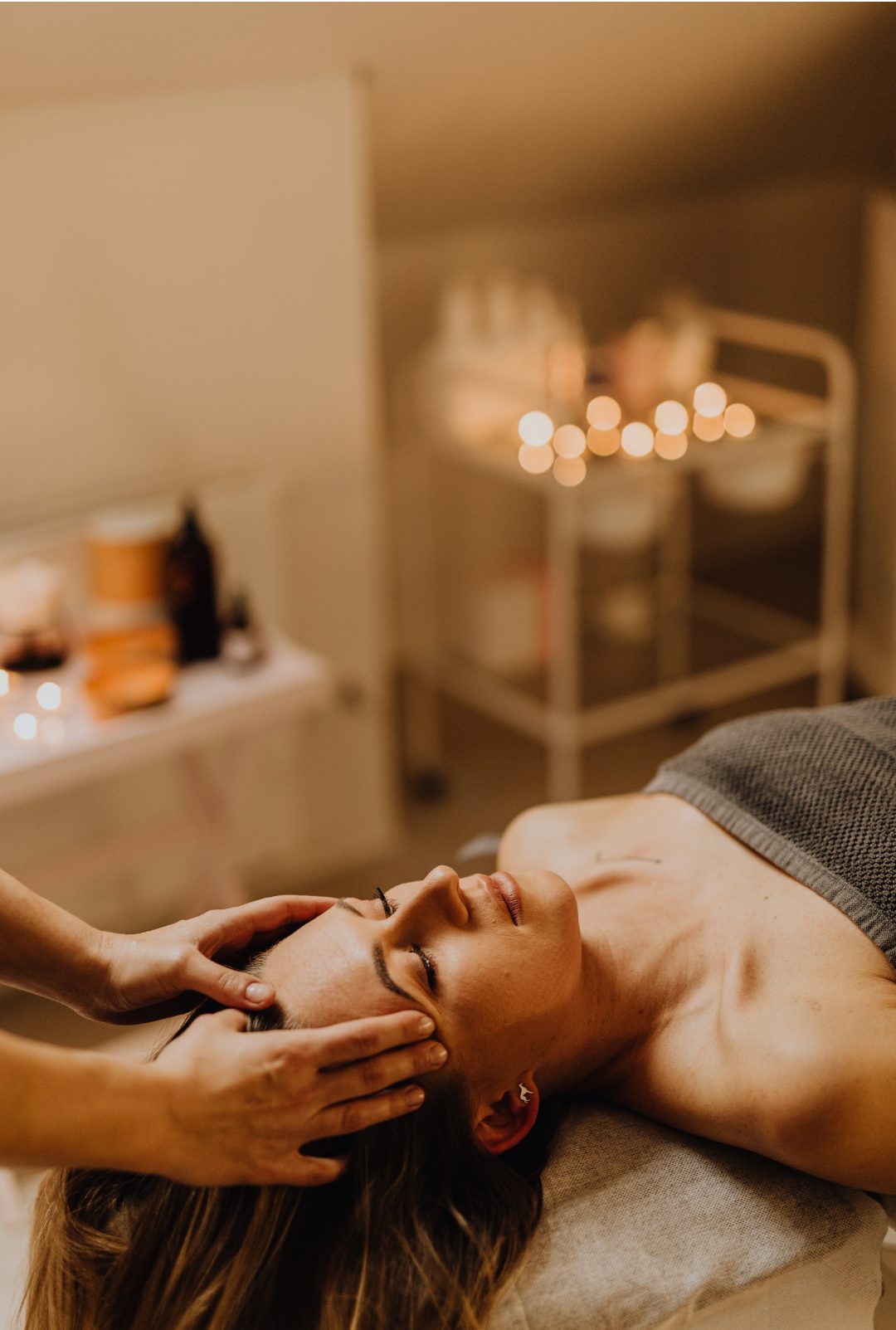 Client receiving a relaxing treatment in a candlelit room at Stillwater Wellness
